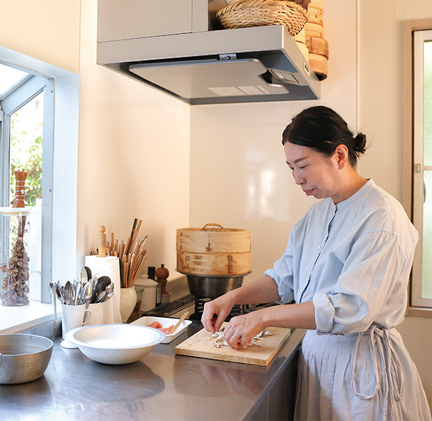 キッチンで調理する中川たまさん