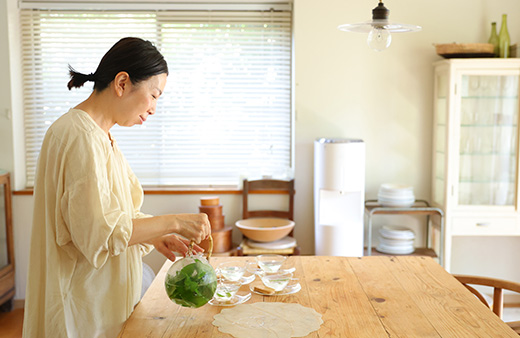 ウォーターサーバーのそばで料理をする中川たまさん