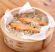 せいろにクッキングシートを敷いて米と鮭をのせる